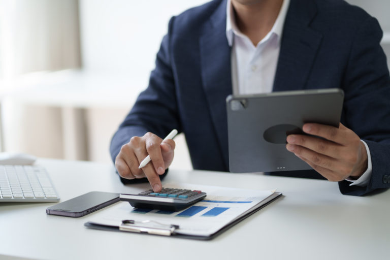 Close Up View Of Businessman Working In The Office Room While Using Calculator In The Office Room. - A J e Oliveira Associados | Advocacia em São Paulo