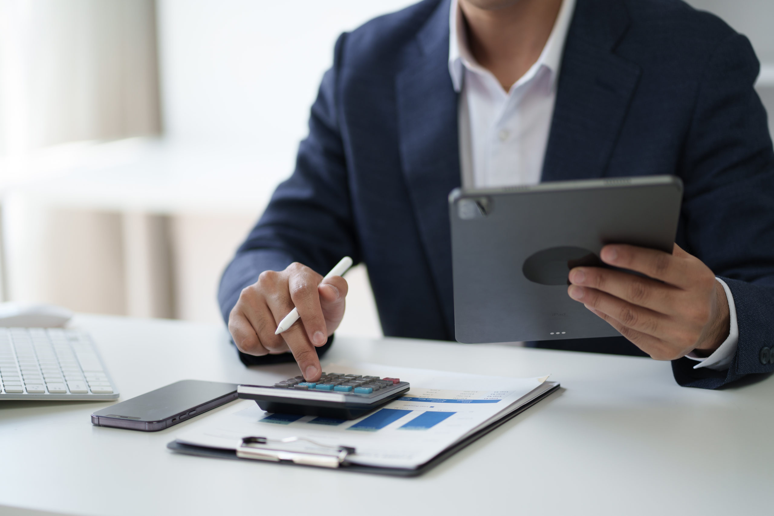 Close Up View Of Businessman Working In The Office Room While Using Calculator In The Office Room. - A J e Oliveira Associados | Advocacia em São Paulo